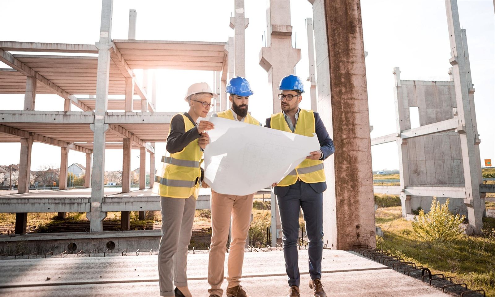 Architects reviewing building plans on a construction site
